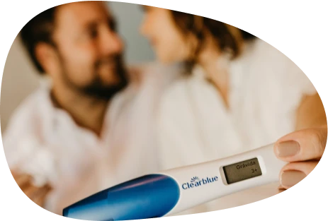 Couple holding a pregnancy test and showing affection in a loving way to one another.